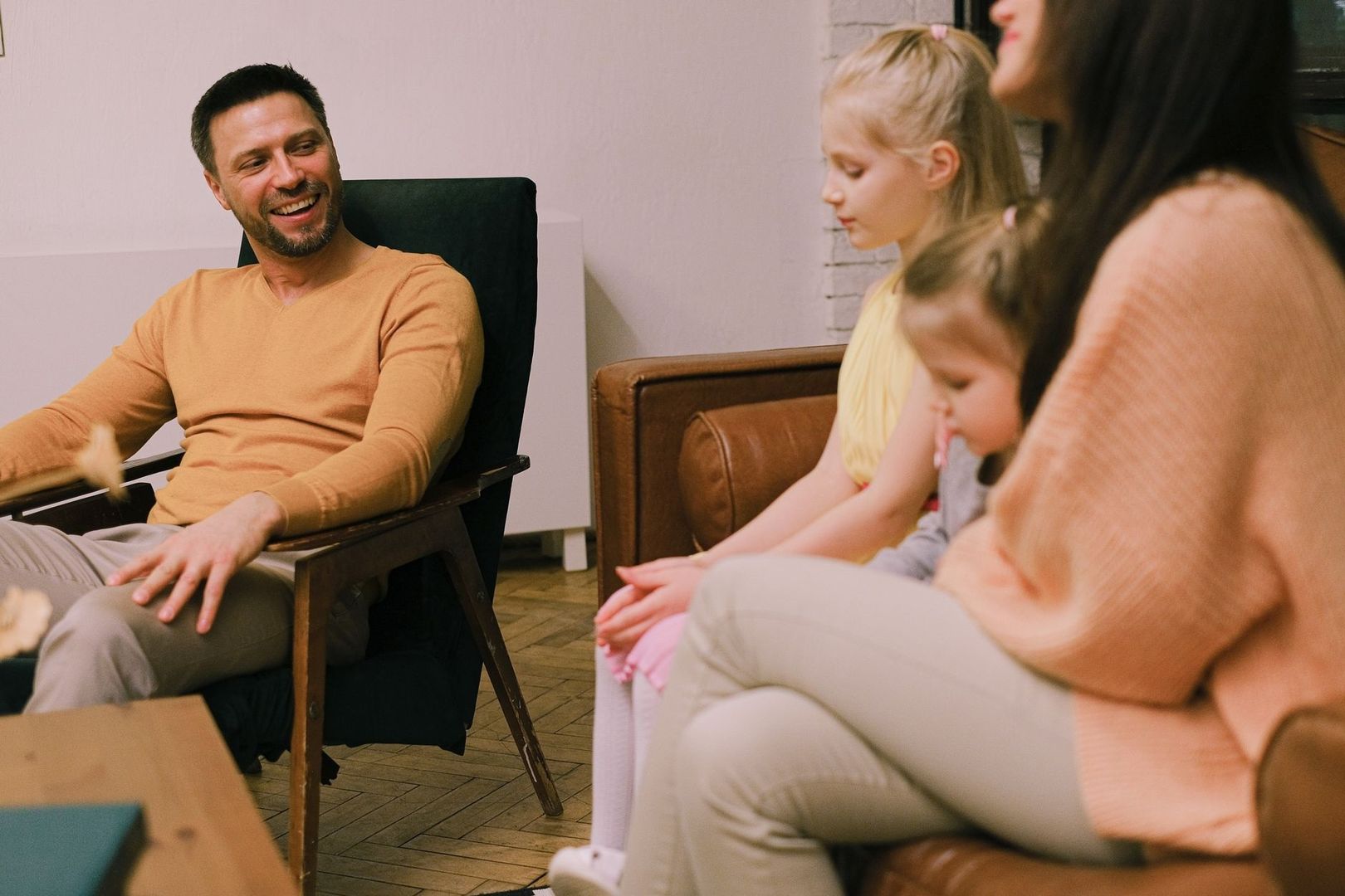 Familj sitter tillsammans i ett vardagsrum under ett samtal